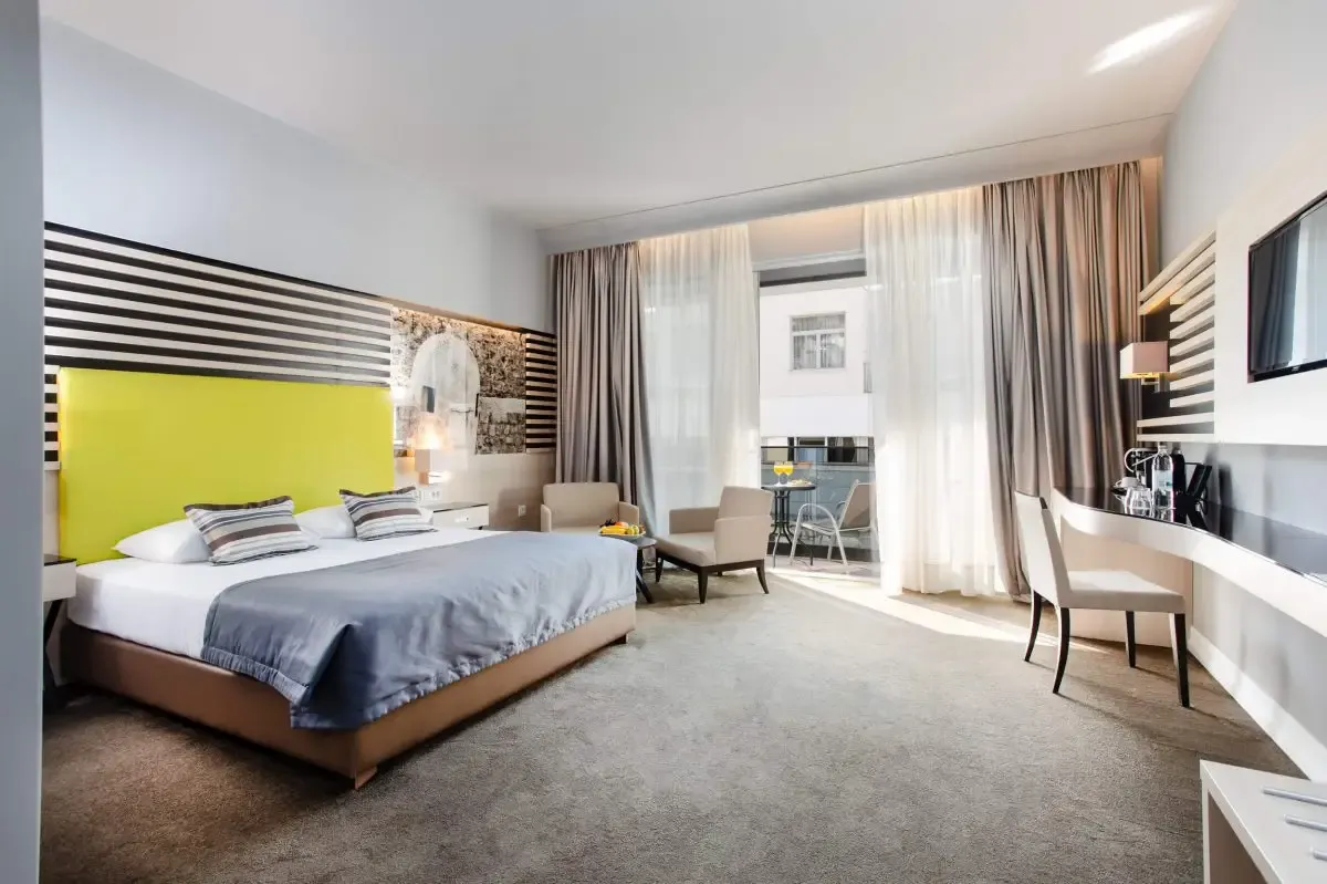 Hotel Lero, Dubrovnik double bedroom with yellow feature wall and armchair