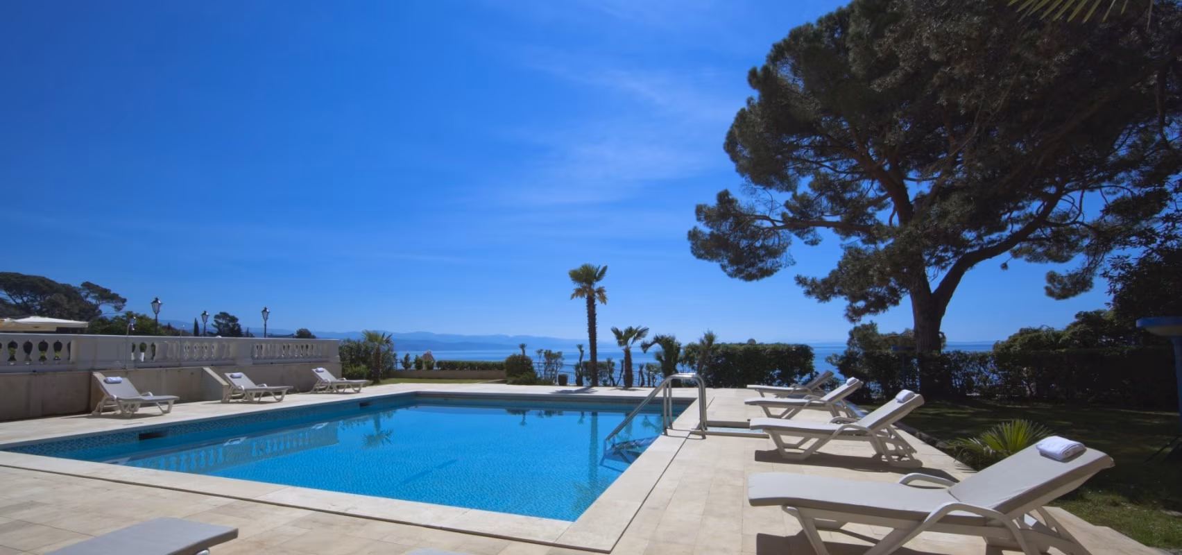 Hotel Kvarner outdoor pool with loungers, palms and sea view