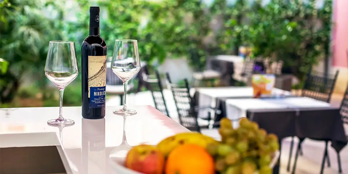 Hotel Cornaro garden table with red wine, glasses and fruit