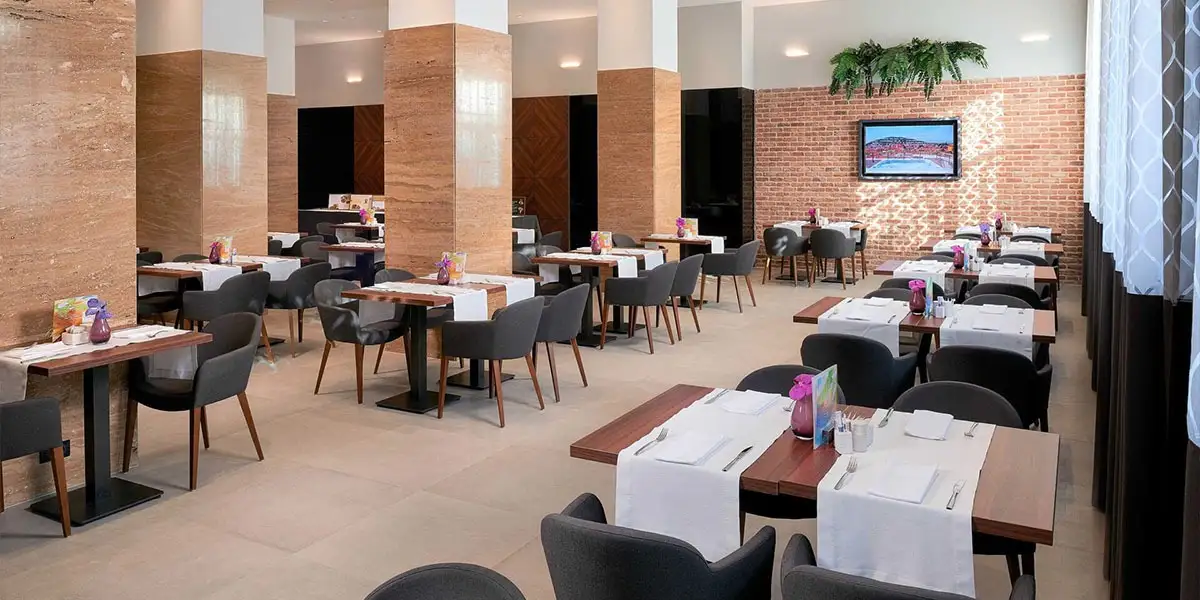 Hotel Cornaro restaurant with wooden columns and dark chairs