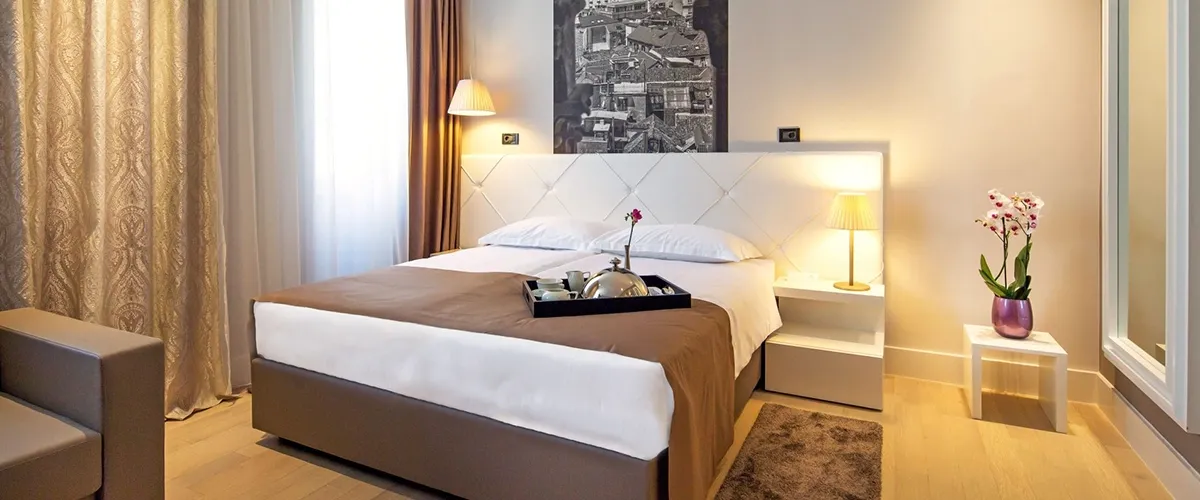 Hotel Cornaro double bedroom with breakfast tray and aerial city photo