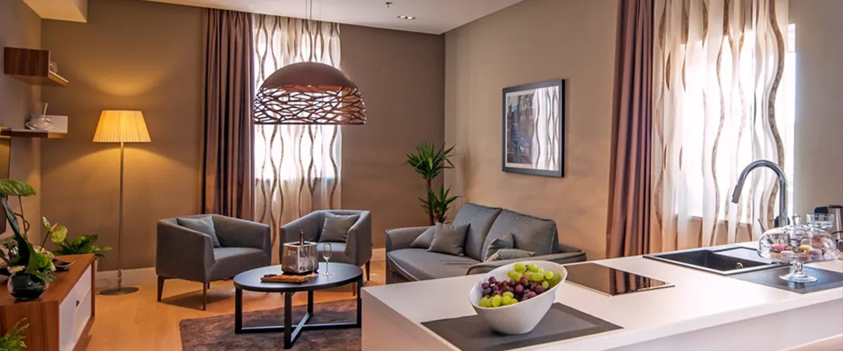 Hotel Cornaro sitting area with grey sofa, armchairs and grapes