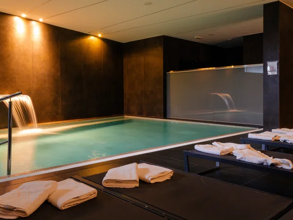 Gospoja indoor pool with dark stone surround and towels