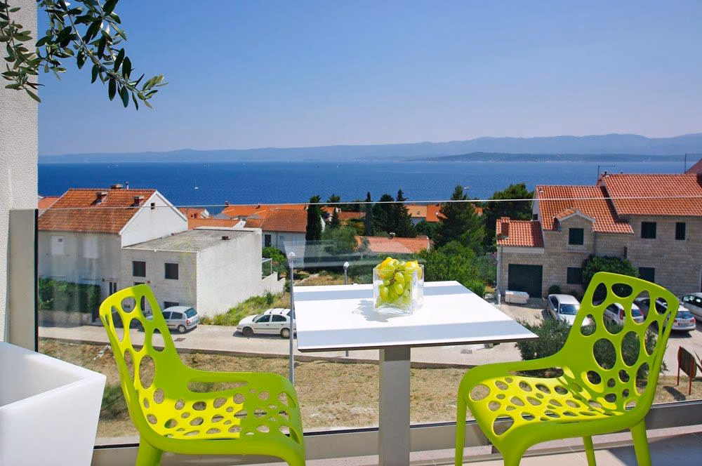 Boutique Hotel Bol terrace with lime green chairs overlooking rooftops and sea