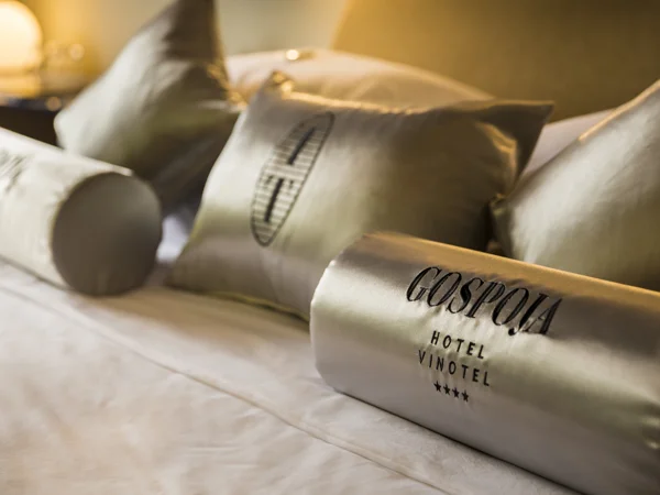 Gospoja pillows with a branded welcome gift on the bed