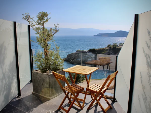 Gospoja balcony with wooden table and chairs overlooking the sea