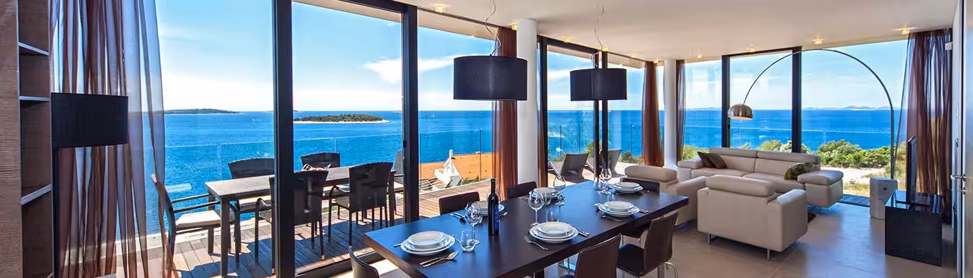 Golden Rays Luxury Resort dining table with sea view through tall windows