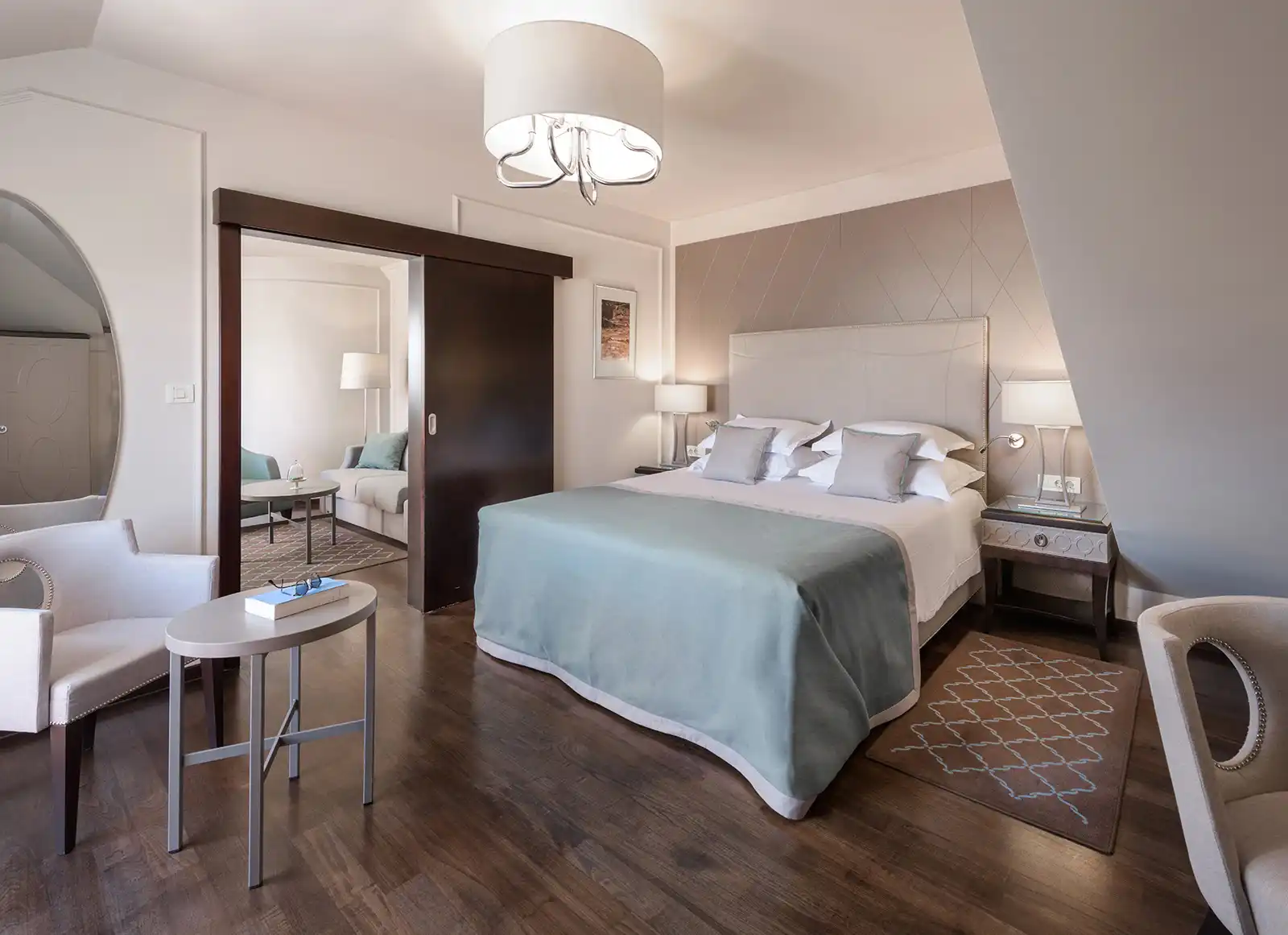 Boutique Hotel Bastion double bedroom with chandelier, dark wood floor and desk