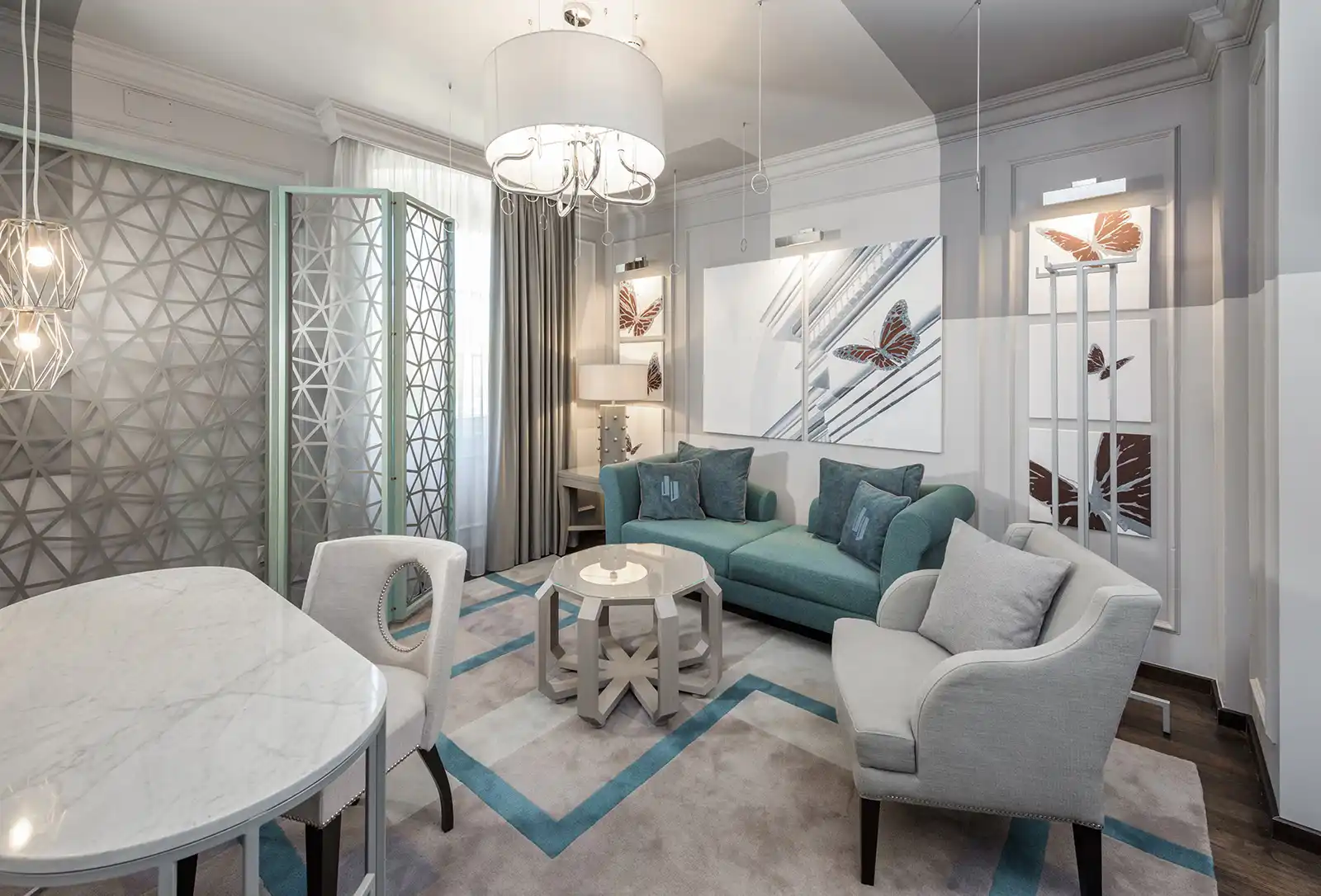 Boutique Hotel Bastion lounge with blue sofa, white armchairs and chandelier