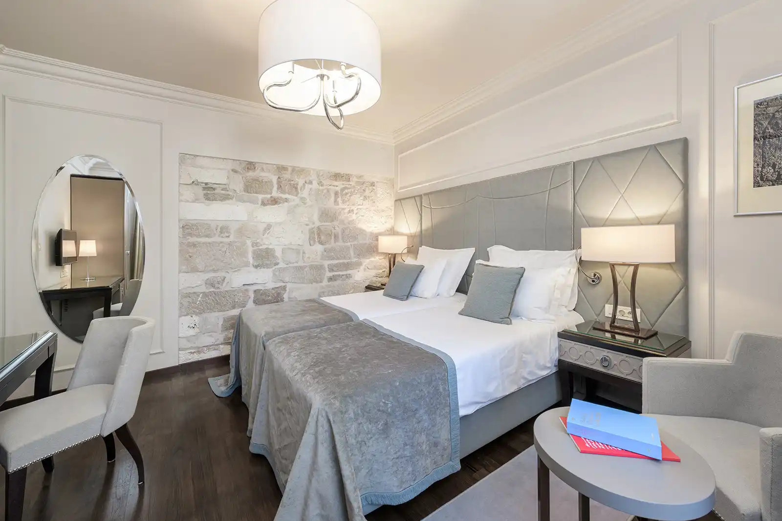 Boutique Hotel Bastion bedroom with grey headboard and map-print wall