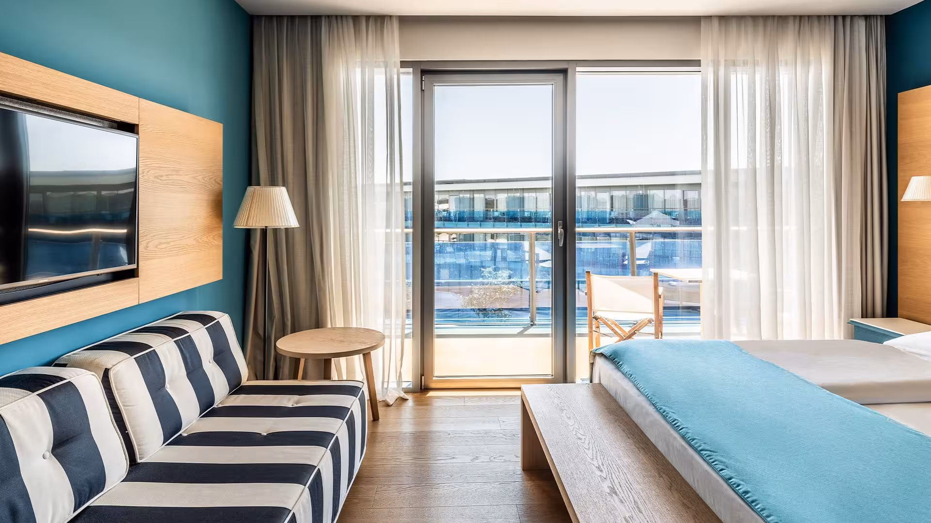 Falkensteiner Hotels Iadera/Senia Apartments room with striped armchair and balcony overlooking the sea