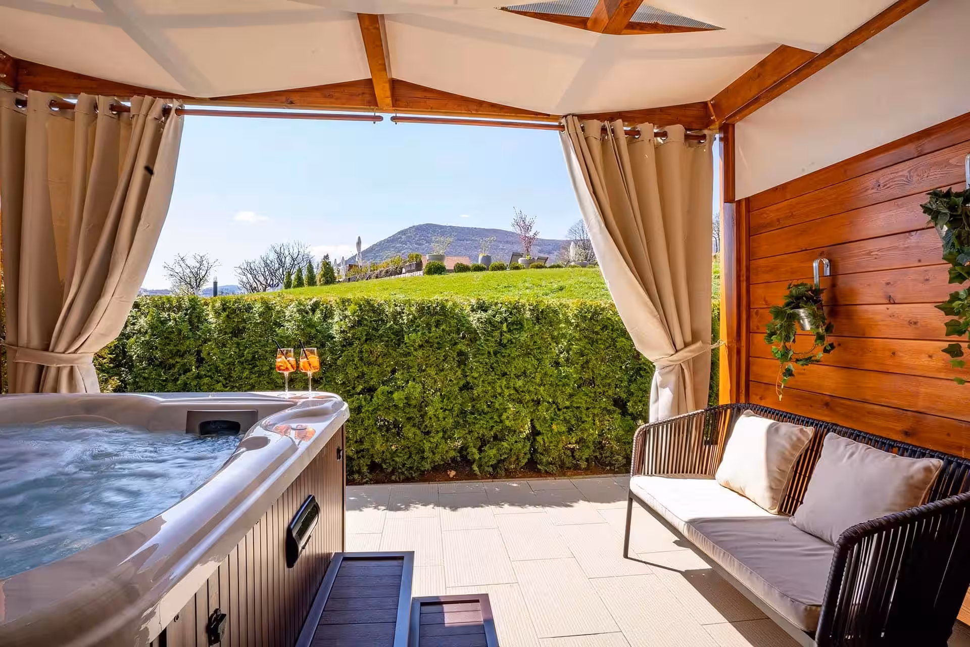 Degenija Hotel private hot tub on a curtained terrace with countryside view