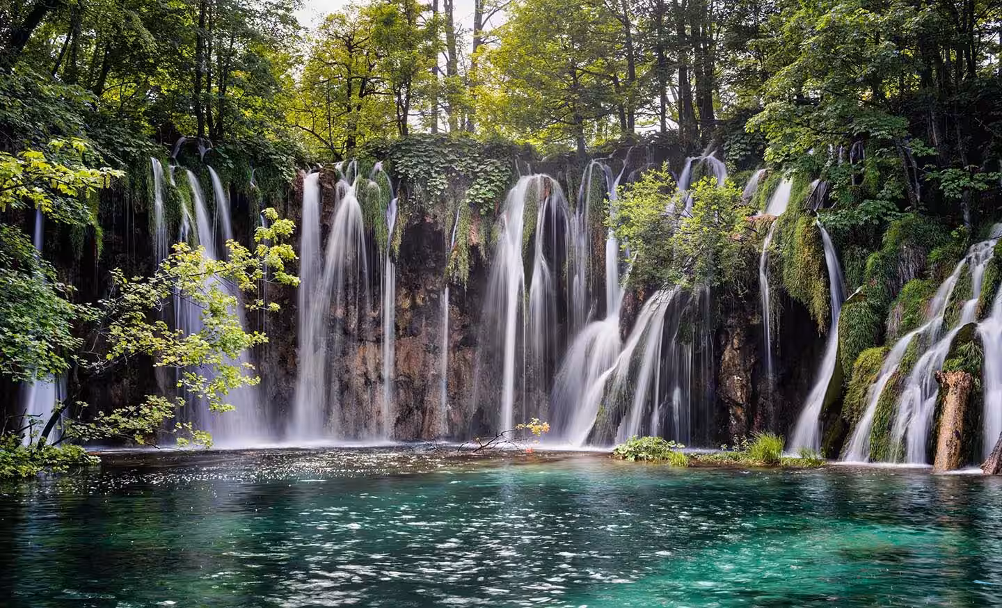 Degenija Hotel waterfalls cascading into a turquoise lake