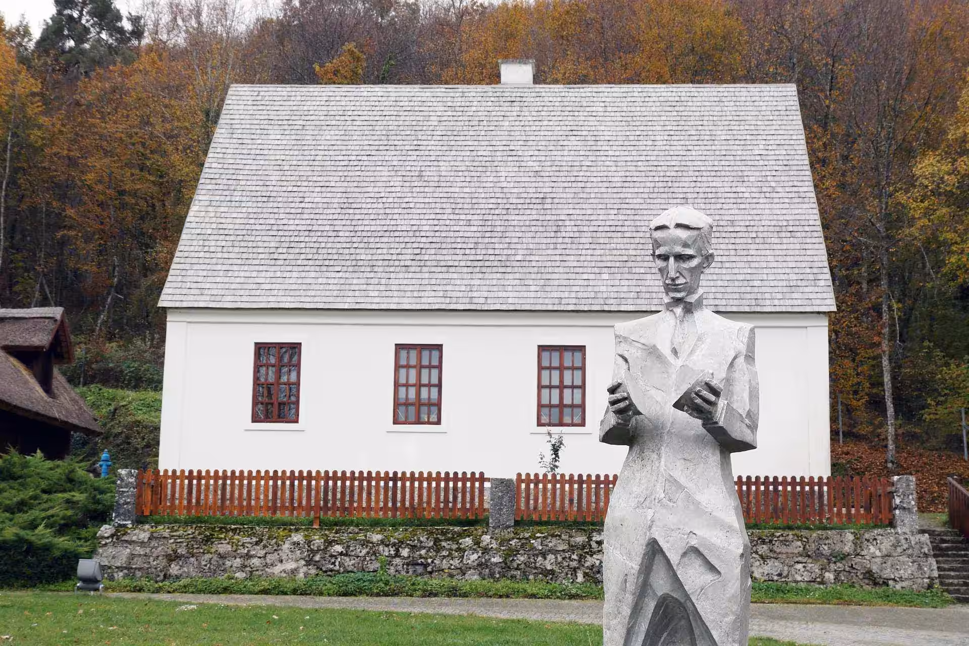Degenija Hotel white house with a statue in front