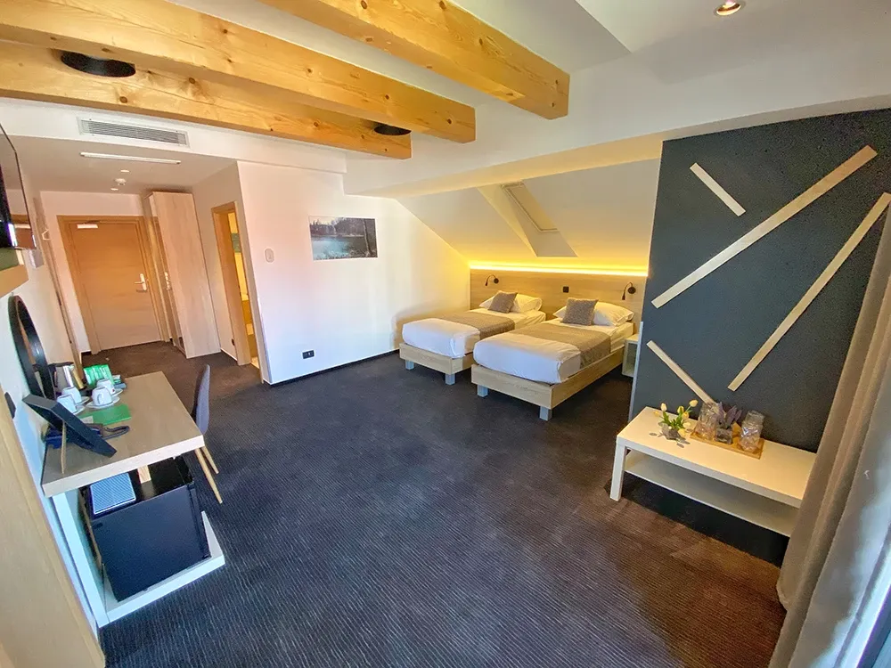 16 Lakes attic room with single beds, wooden beams and dark carpet