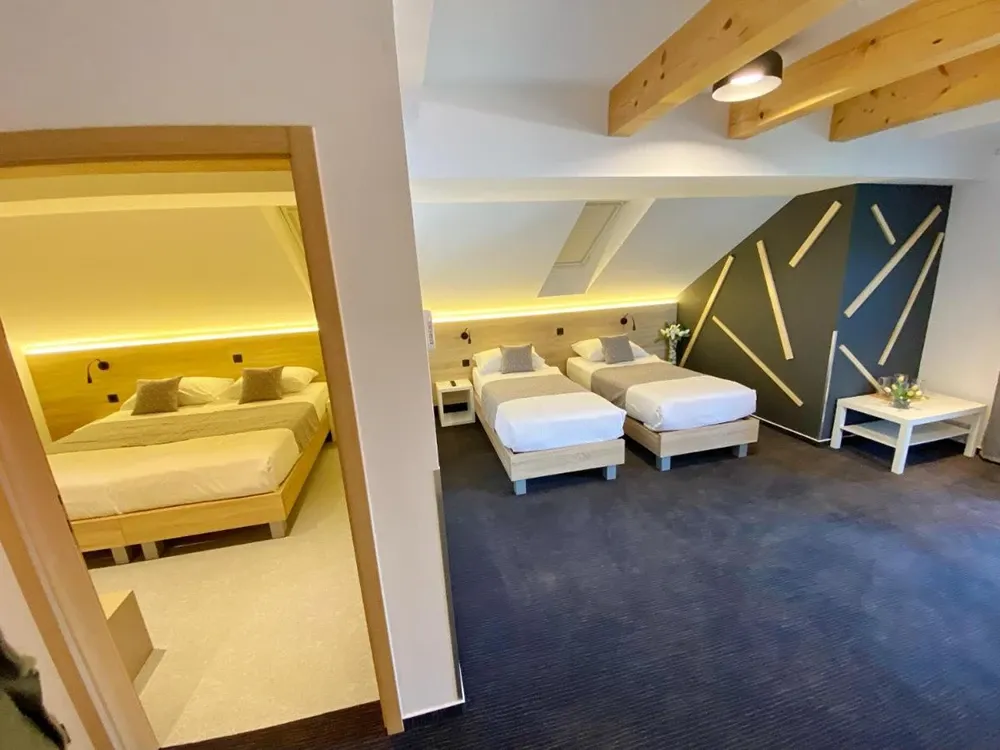 16 Lakes attic room with three single beds under sloping wooden beams