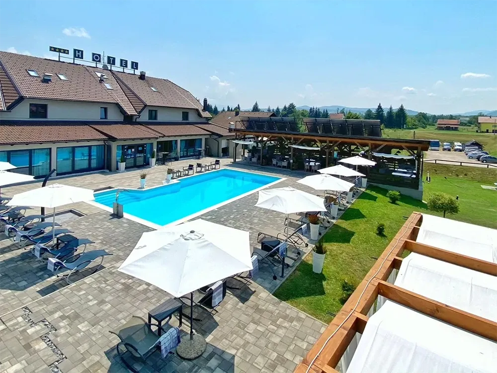 16 Lakes outdoor pool with parasols and sun loungers beside the hotel