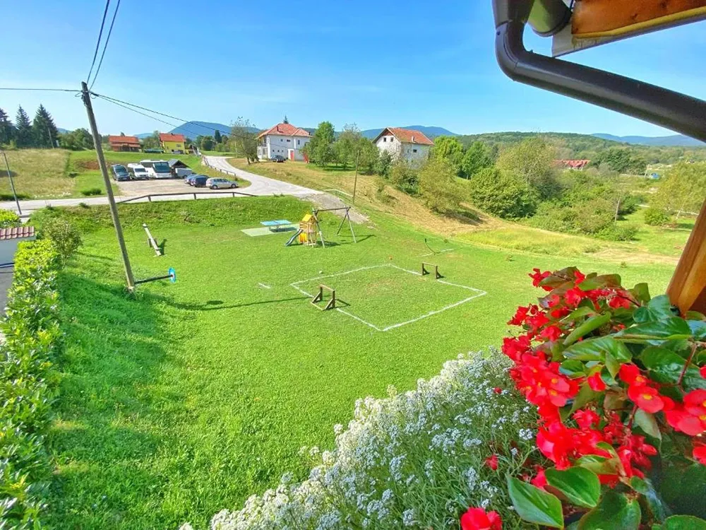16 Lakes sloping lawn with small football pitch and red geraniums