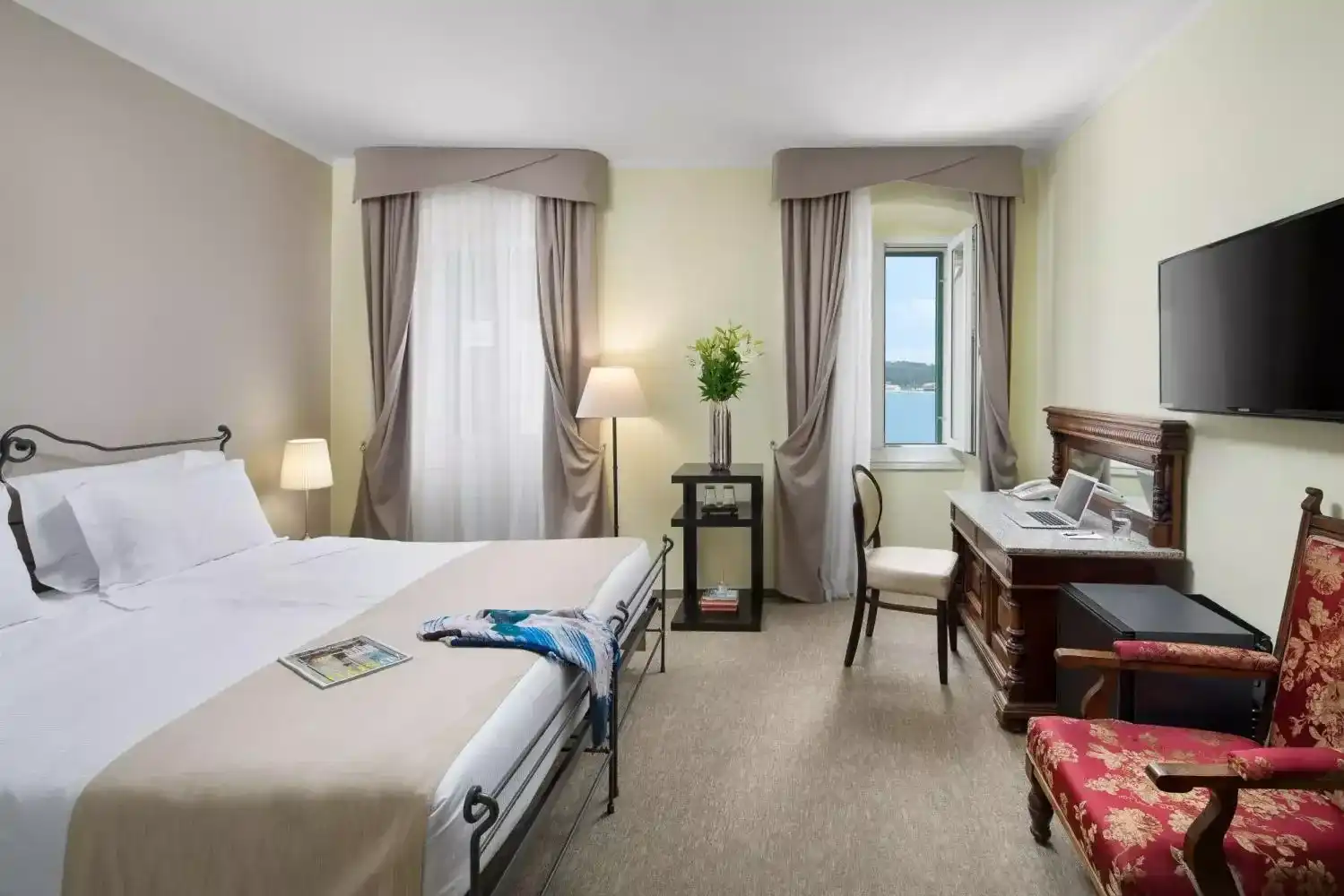 Angelo d'Oro twin room with armchair, desk and long curtains