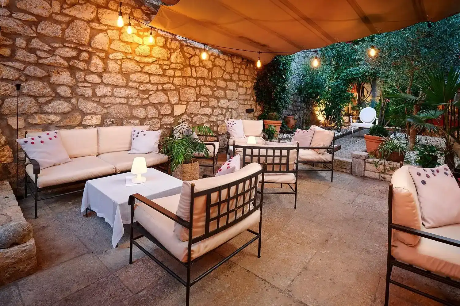 Angelo d'Oro stone courtyard terrace with white cushioned sofas
