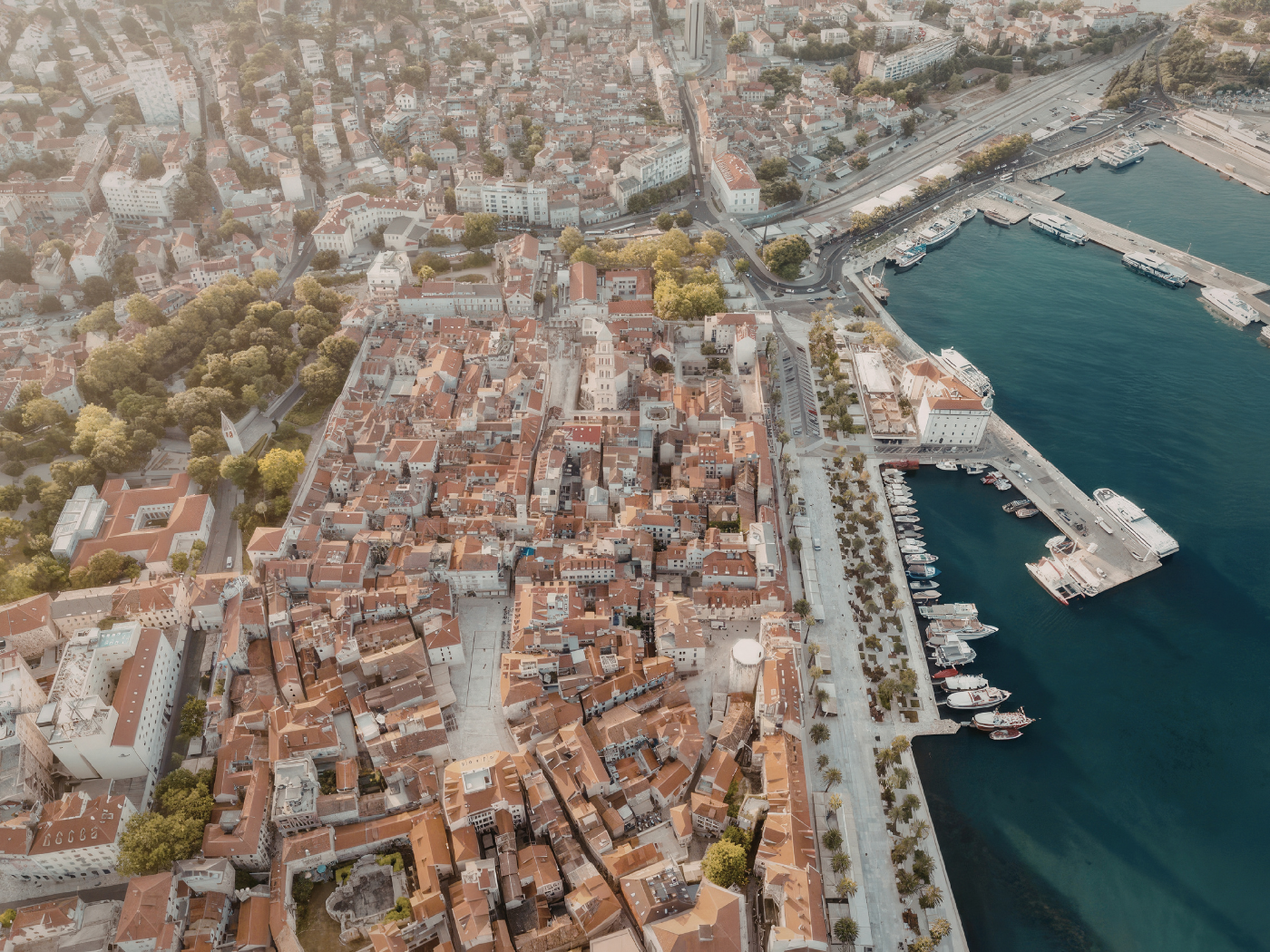 Aerial view of a dense old town grid beside a harbour