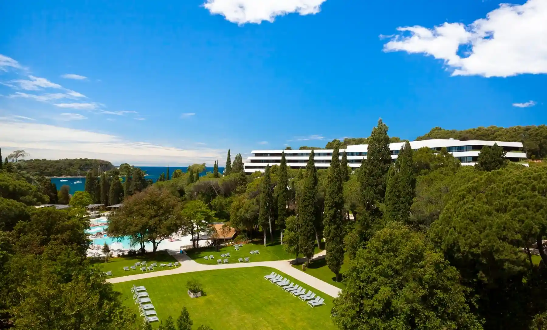 Lone hotel building among pine trees with lawns