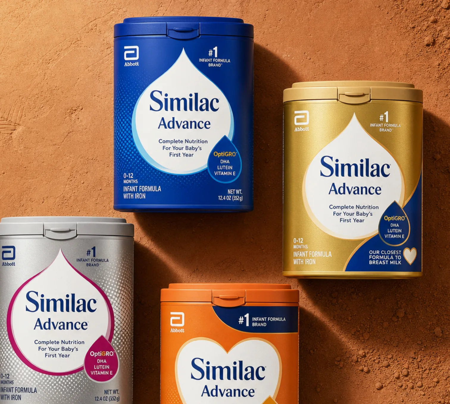 Similac Advance infant formula tubs arranged on a terracotta textured surface