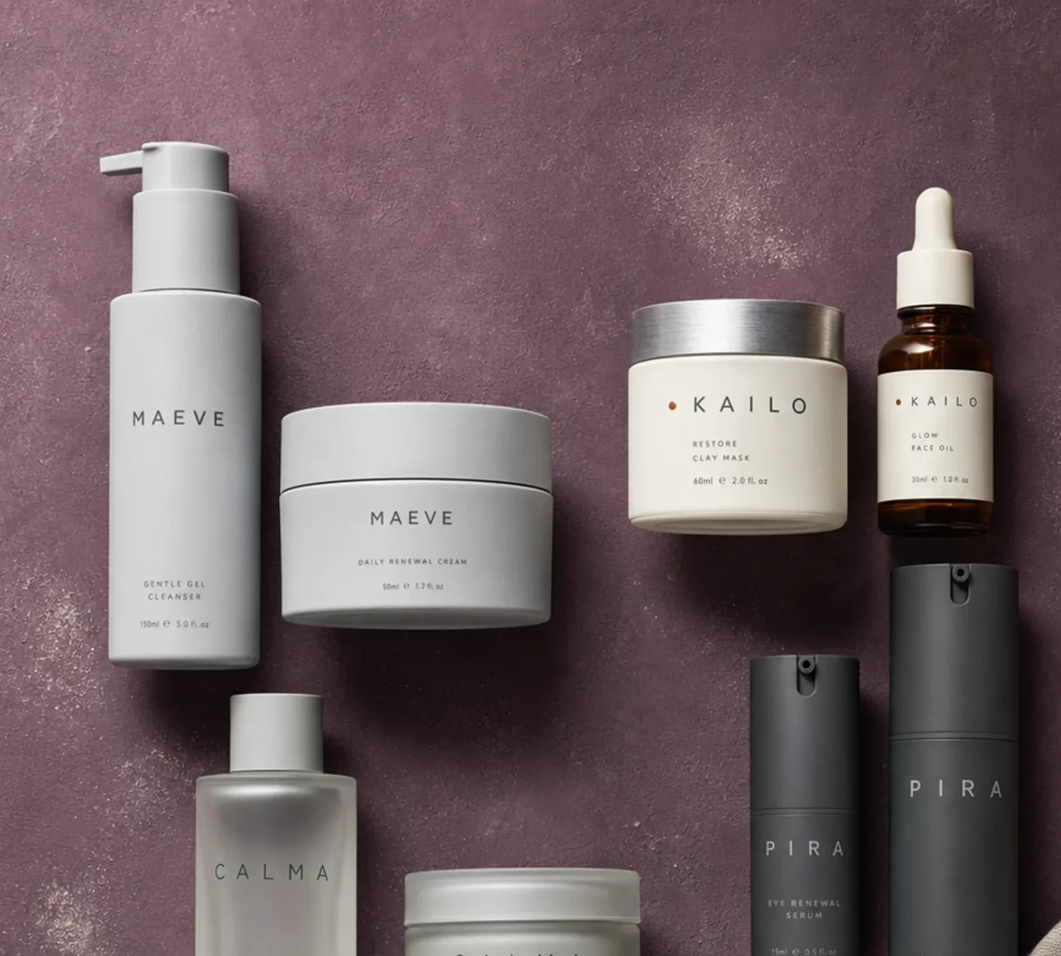 Skincare bottles and jars from rival brands on a mauve surface