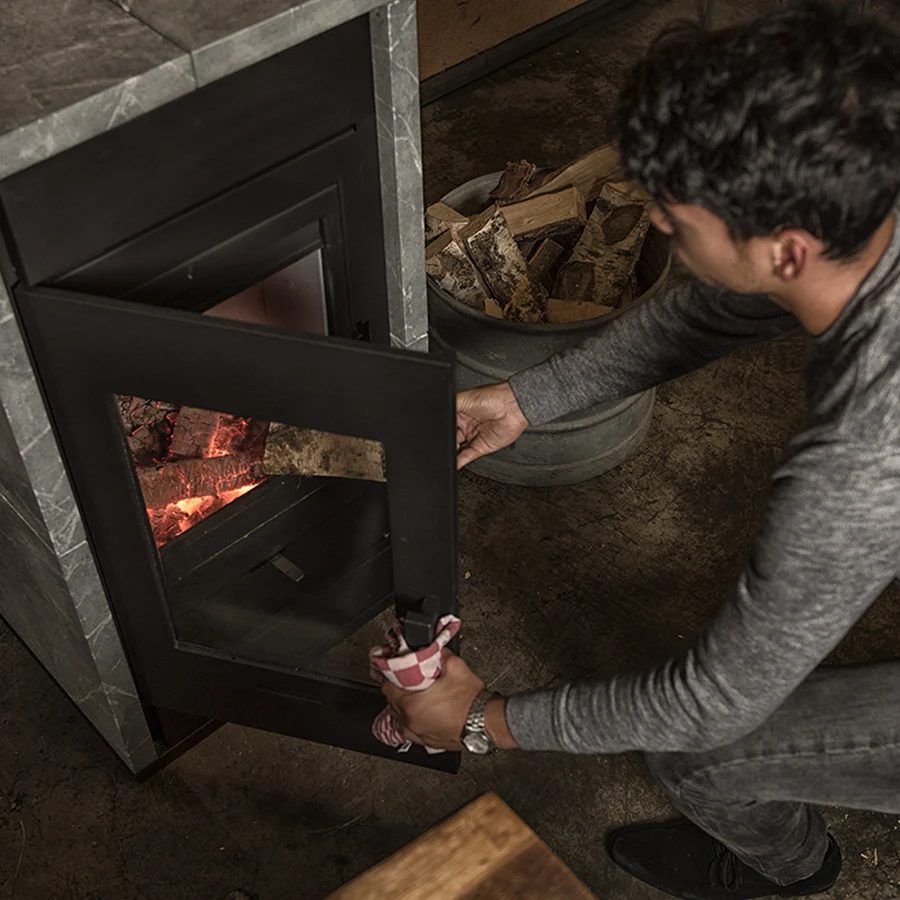 Homme devant feu poêle à bois
