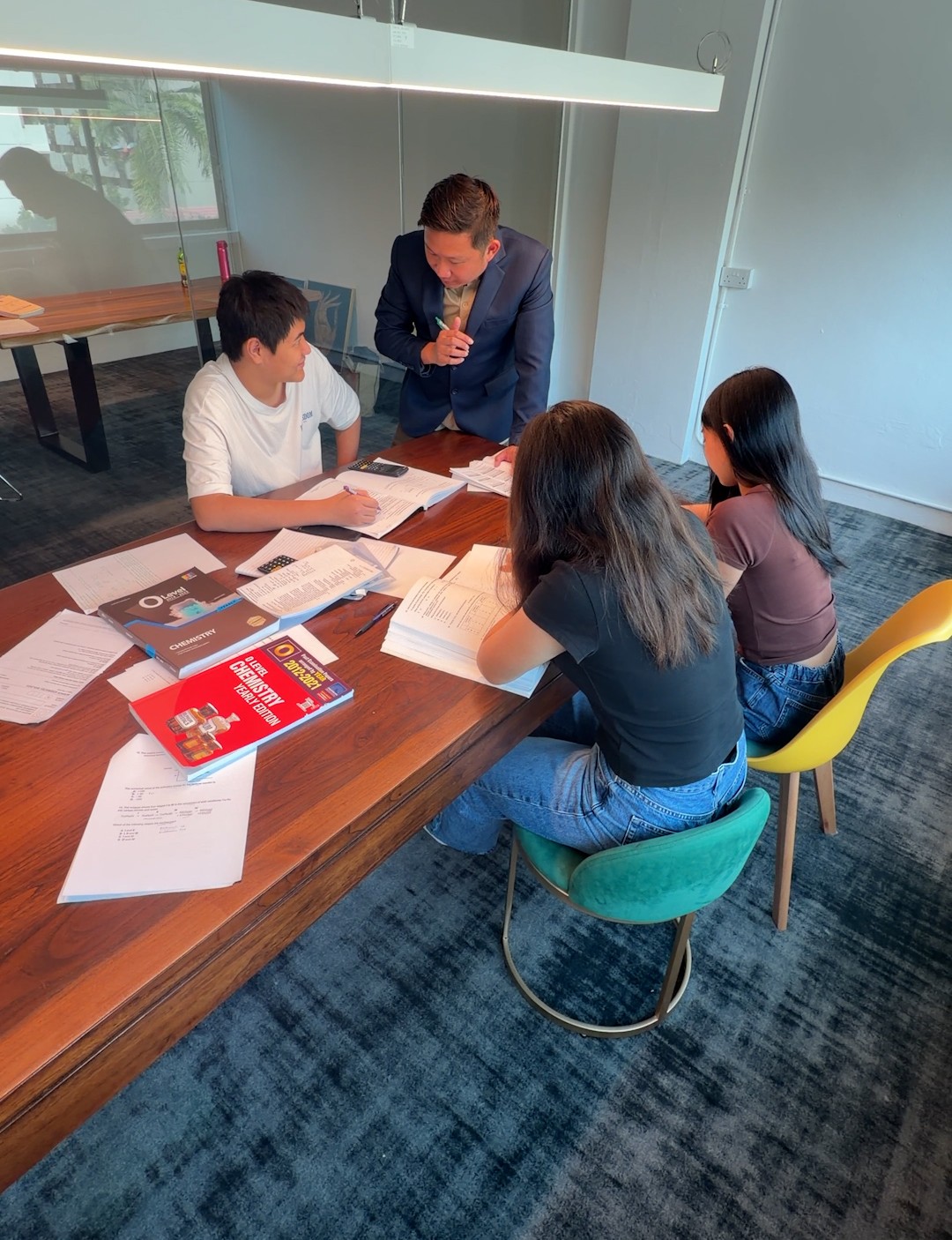 O-Level Chemistry tutor guiding secondary school students during a tuition class