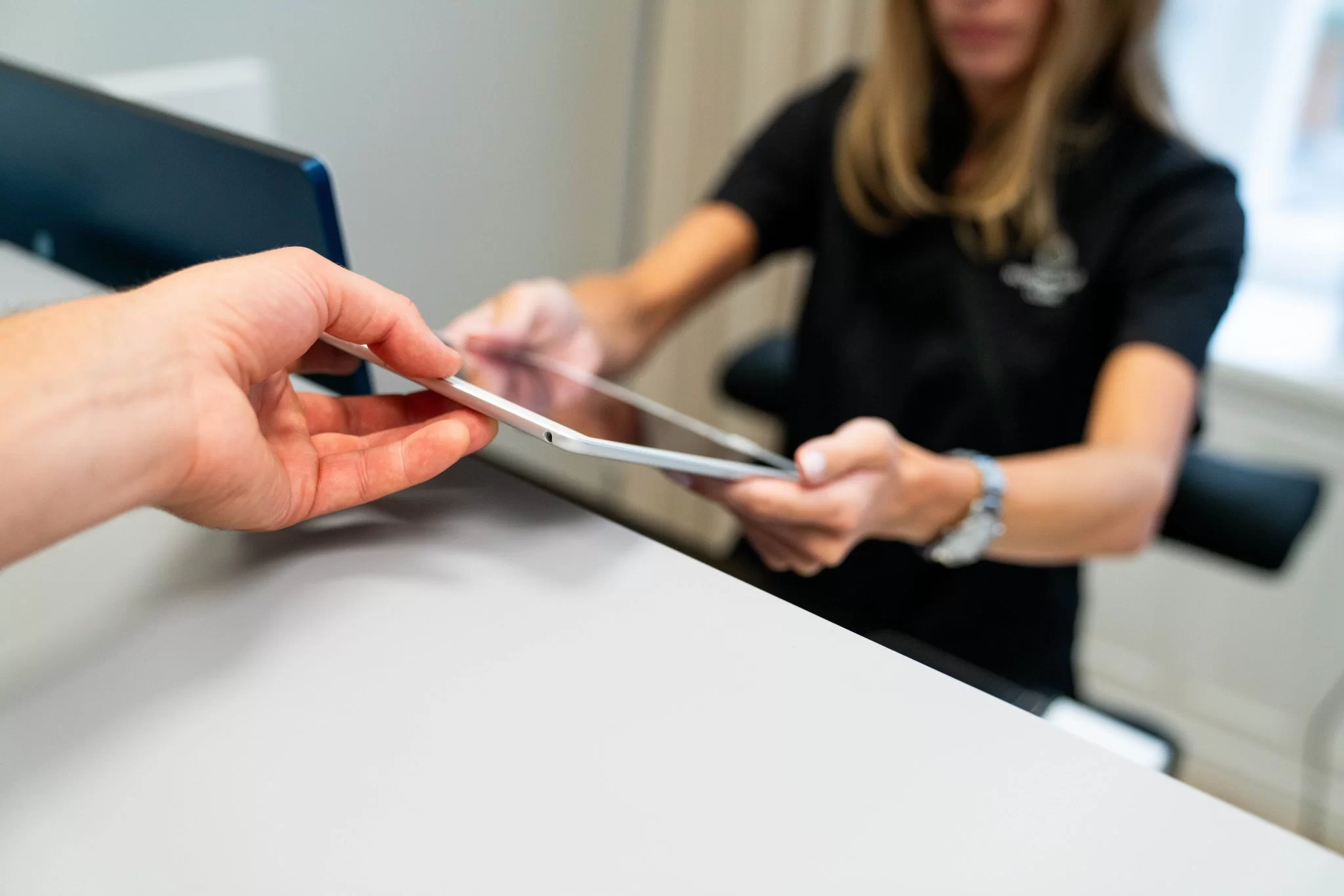 en kvinna ger en ipad till en kund