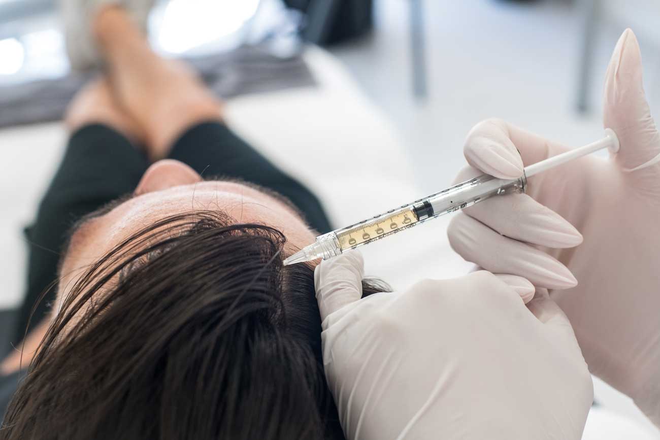 En kvinna får sitt hår undersökt