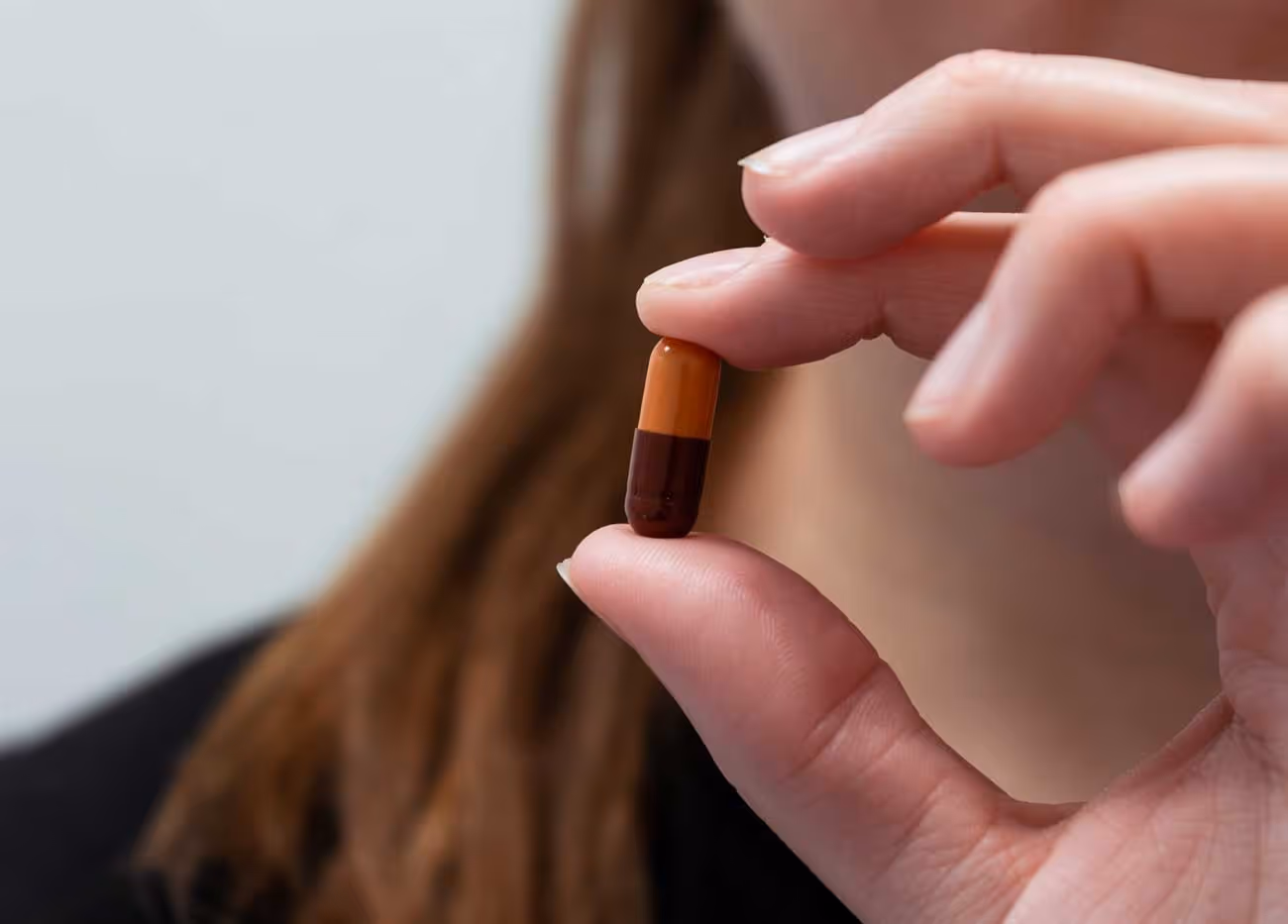 En kvinna håller upp vitaminer