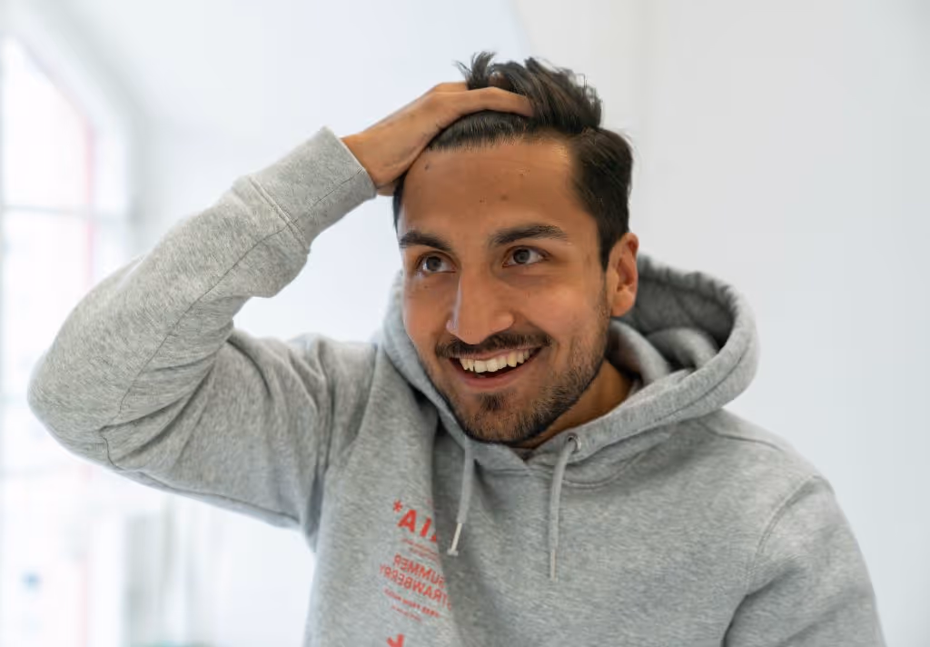 en mand, der tager minoxidil, ser sig selv i spejlet