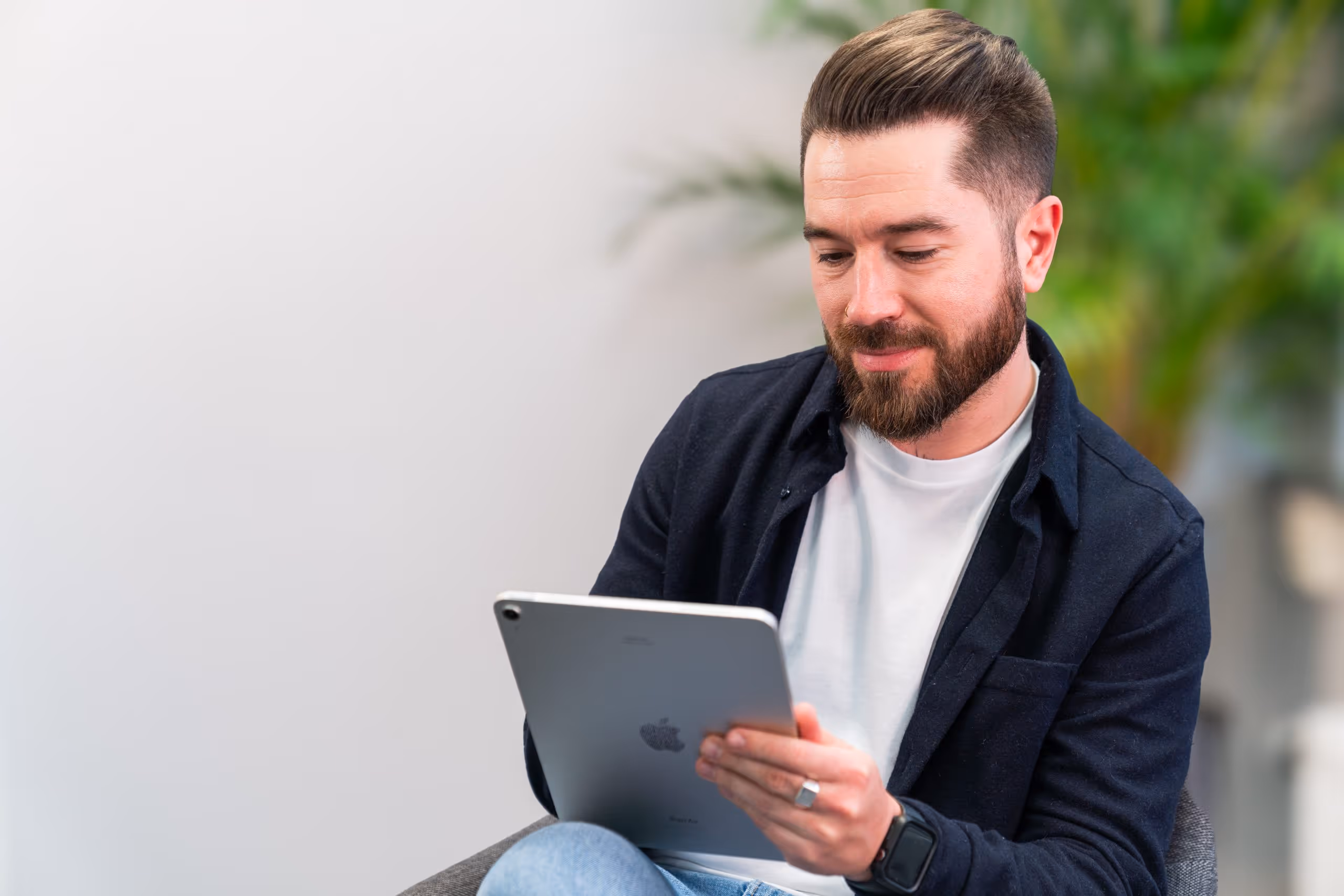 a man peeks at an ipad