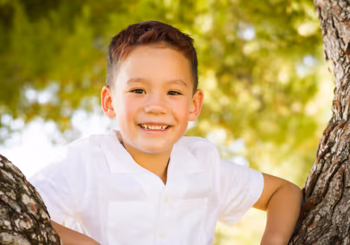 Confident teen with backpack smiling outdoors, benefiting from Neurodivergent Coaching.