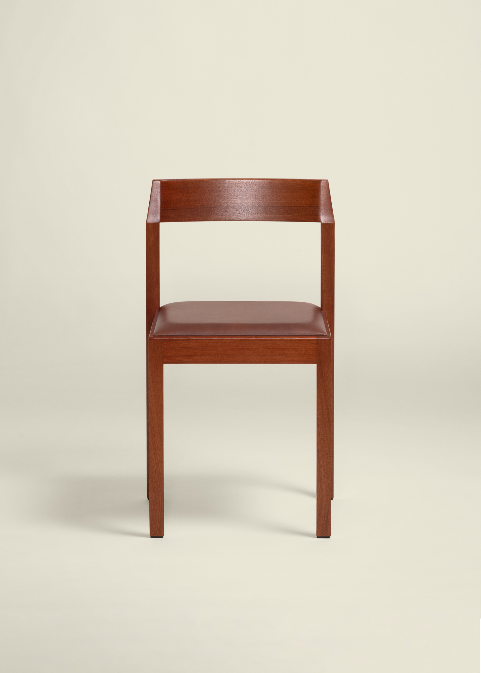 Front view of a modern wooden chair with a simple backrest and a brown cushioned seat.