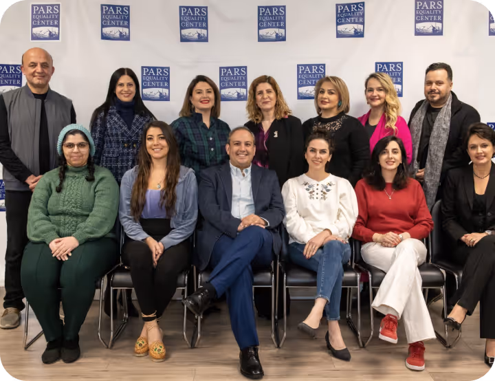 Group of 14 people, diverse in gender and age, posing seated and standing in front of a wall with Pars Equality Center logos.