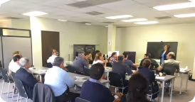 Business professionals attending a presentation in a bright conference room.