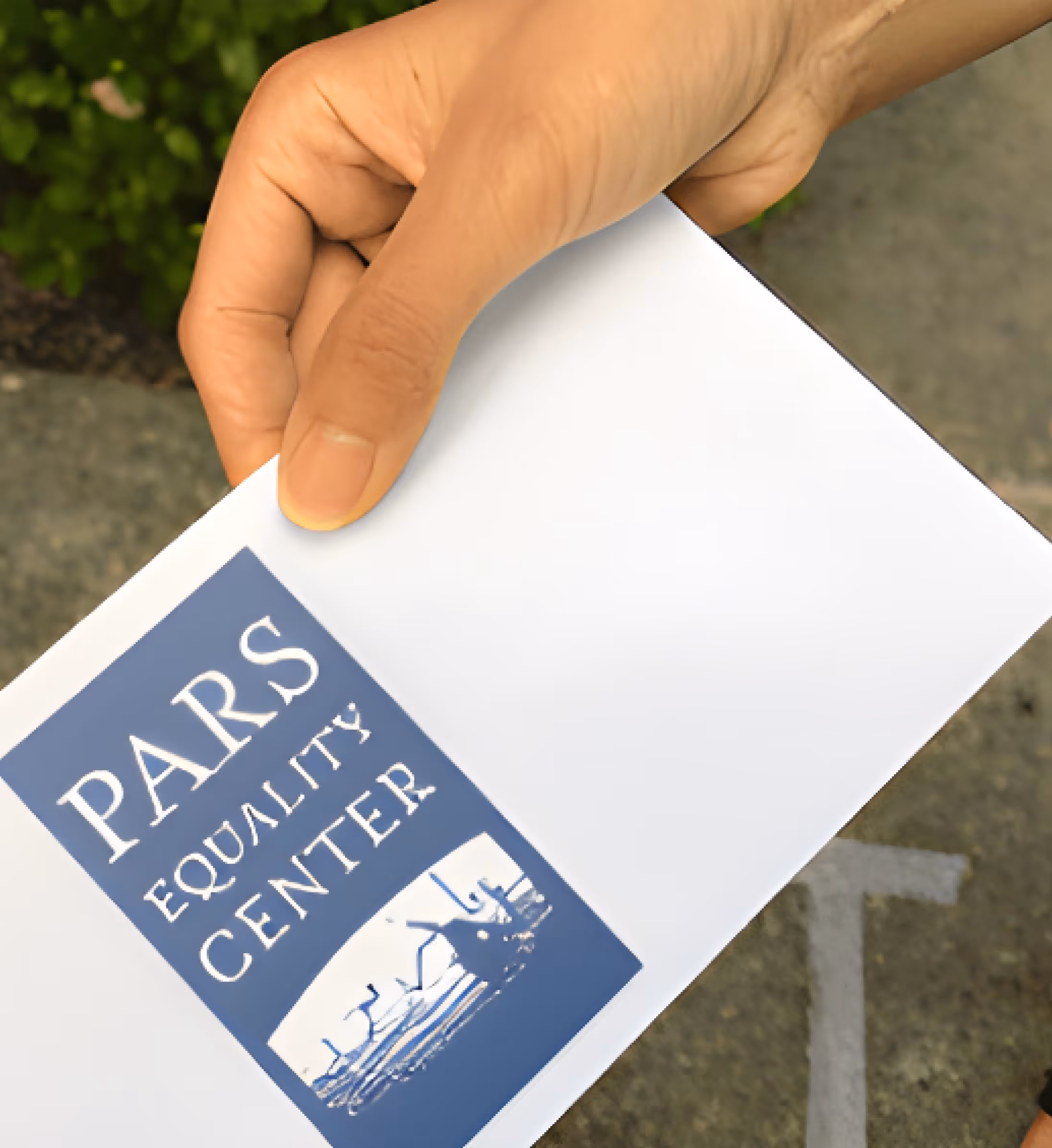 Hand holding an envelope with a blue label that reads 'PARS EQUALITY CENTER' and features an image of an octopus.
