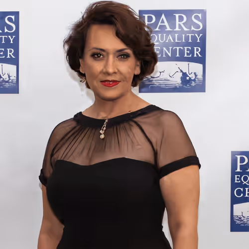 Woman with short brown hair wearing a black sheer top dress at Pars Equality Center event.