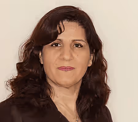 Portrait of a woman with dark brown hair and brown eyes wearing a black top against a plain background.
