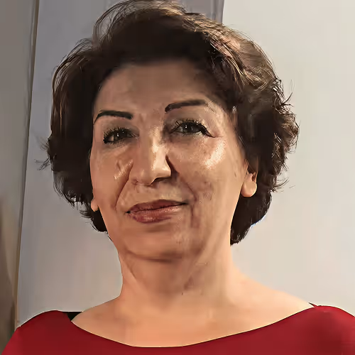 Portrait of a middle-aged woman with short curly hair wearing a red top against a plain background.