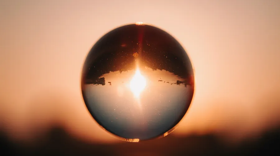 Sun setting behind a glass sphere silhouette — 3d product visualization by Detroit AI Production House, image generation & art direction by Pierrick Jégou