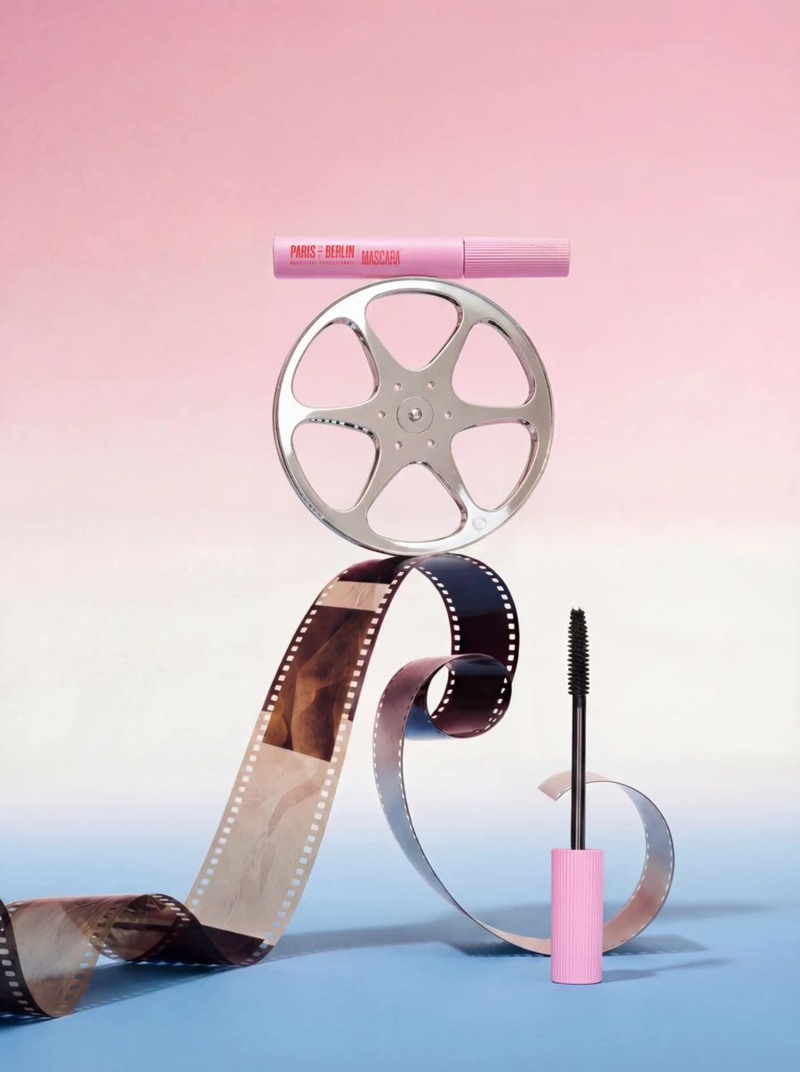 Paris Berlin mascara balanced on a film reel with unspooled filmstrip, print campaign — ai video production by Detroit AI Production House, photography & art direction by SQUAD