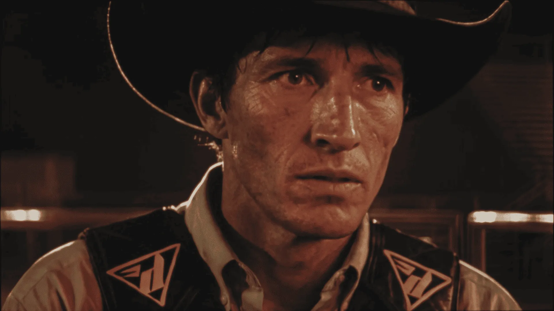 Close-up of a sweat-drenched cowboy in a hat and vest under warm rodeo arena lighting — ai film production by Detroit AI Production House, DOMA manifesto film