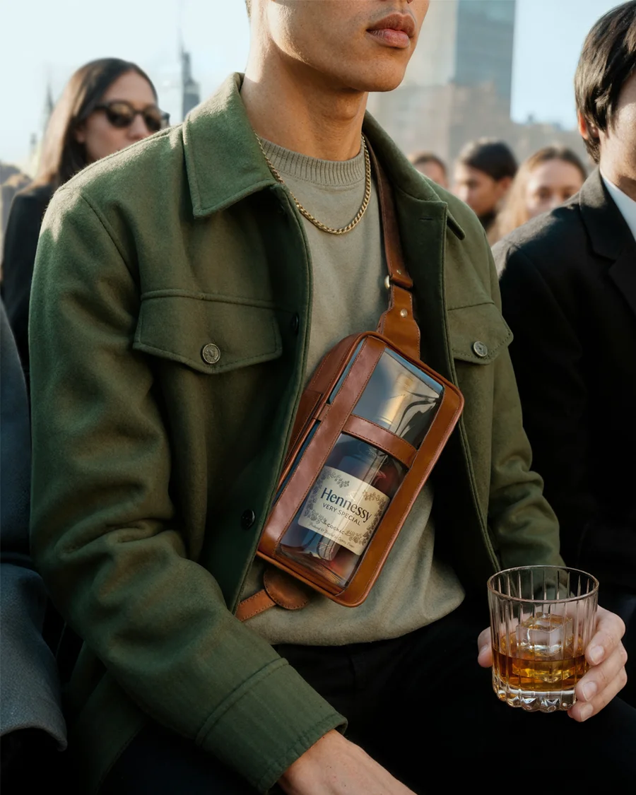 Man in a green jacket holding a Hennessy bottle and glass amid a crowd of onlookers — virtual production studio Detroit, photography & art direction by Detroit AI Production House