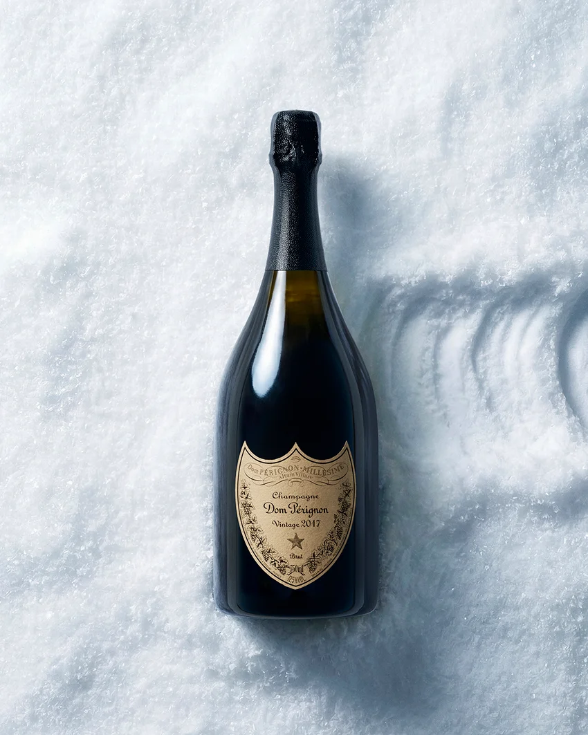 Dom Pérignon bottle standing upright in fresh snow, casting a long diagonal shadow under bright sunlight — ai video production Detroit, photography & art direction by Pierrick Jégou, produced by Detroit AI Production House