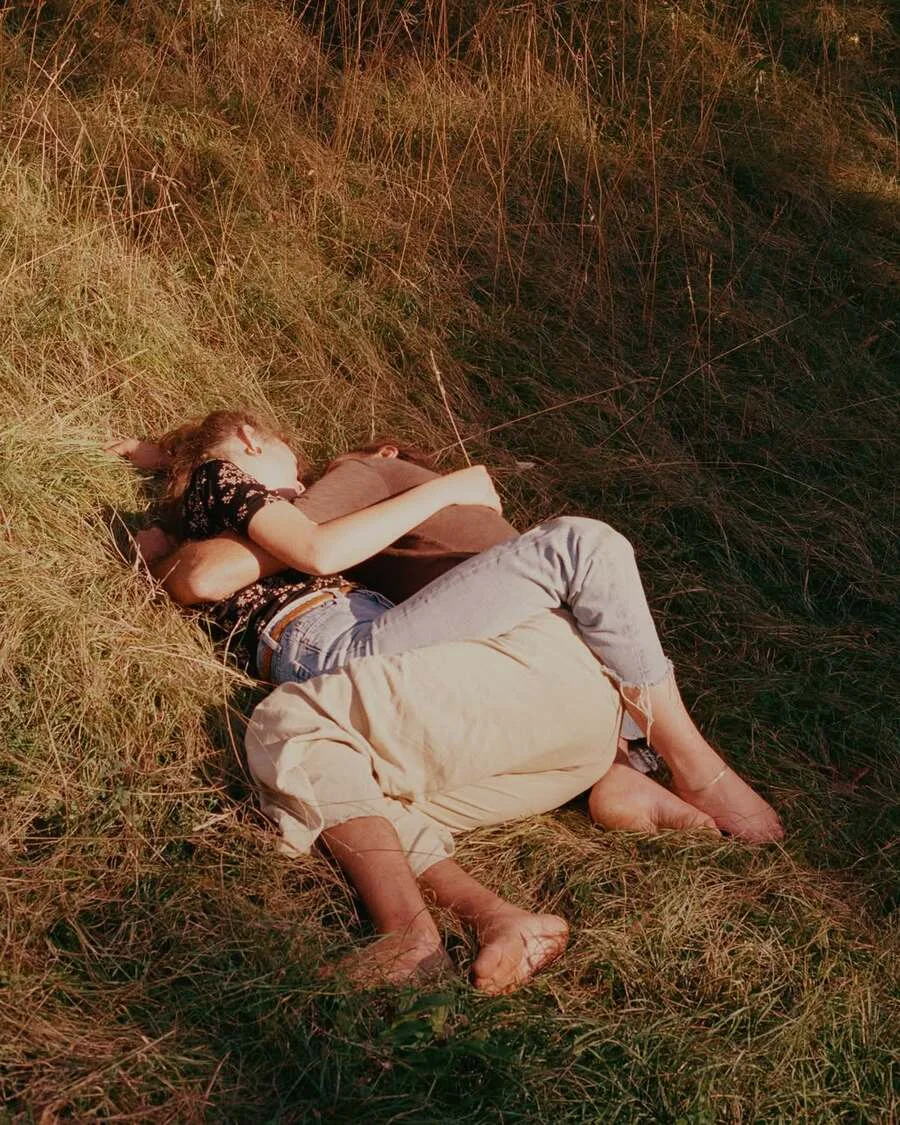 Couple embracing lying in golden grass field — ai video production by Detroit AI Production House, image generation & art direction by Alys