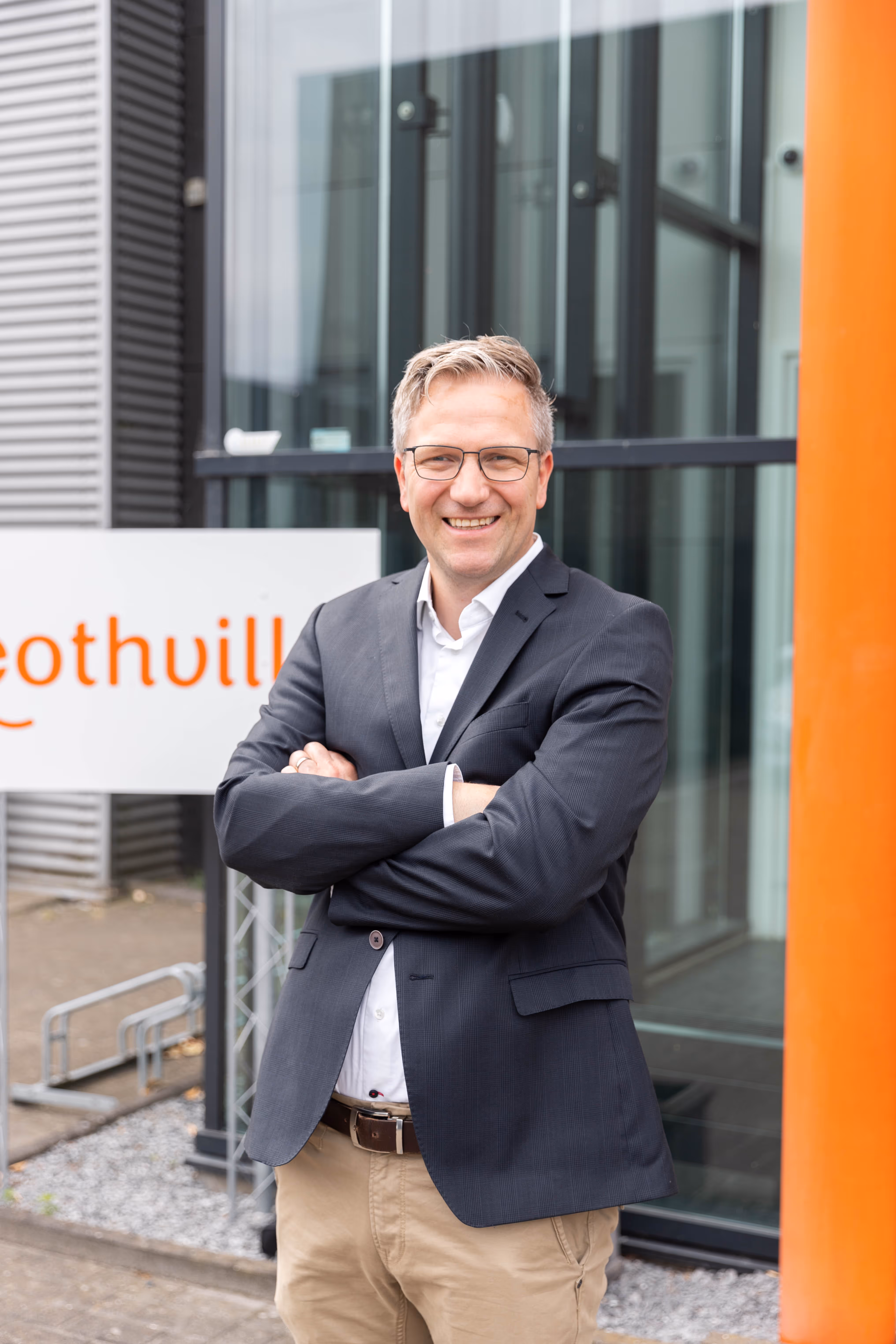Oprichter van Boothville staat lachend met gekruiste armen voor het Boothville hoofdkantoor.